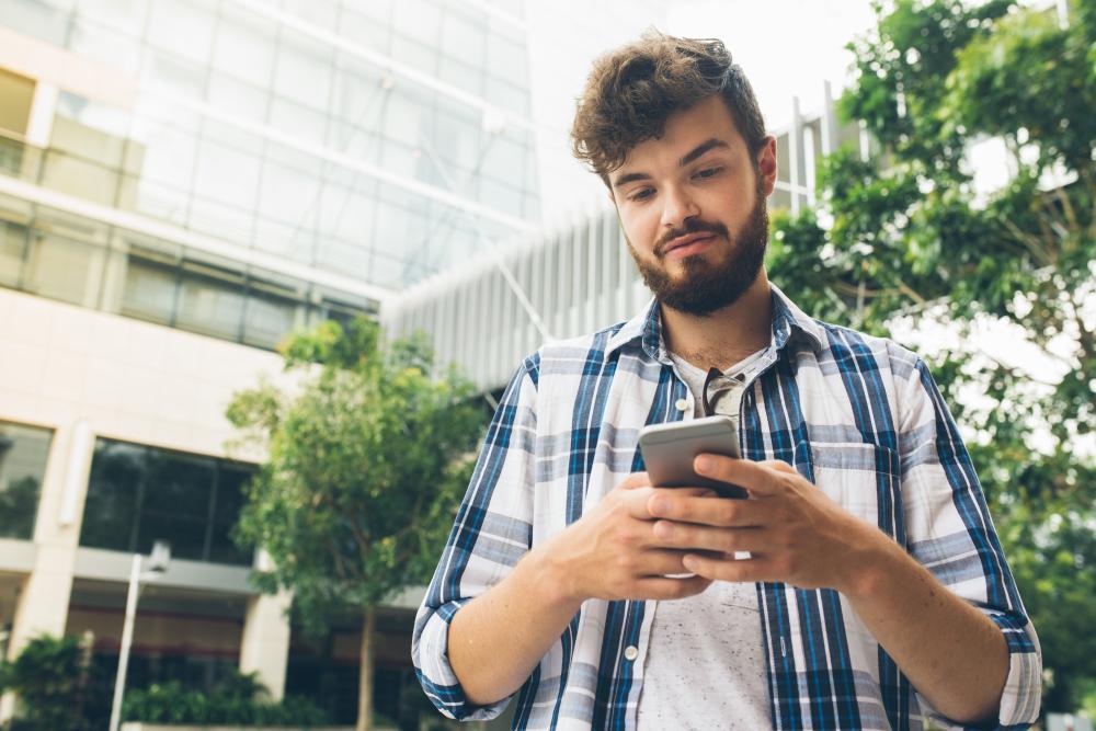 A man is pictured using his smartphone on the street