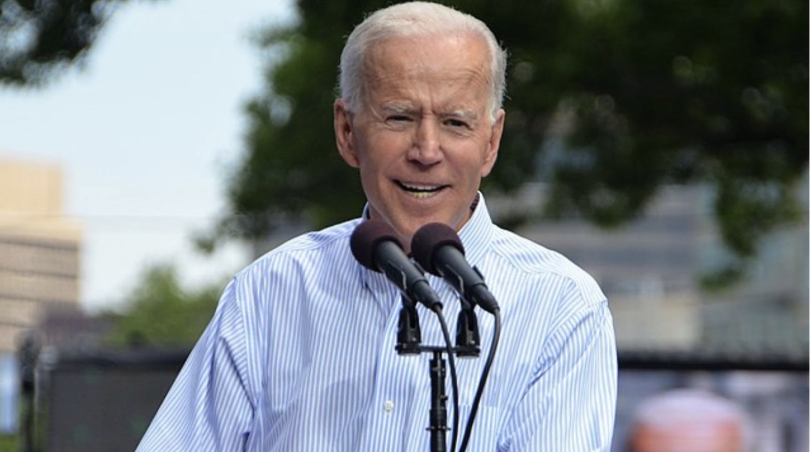 Joe Biden standing behind two microphones.