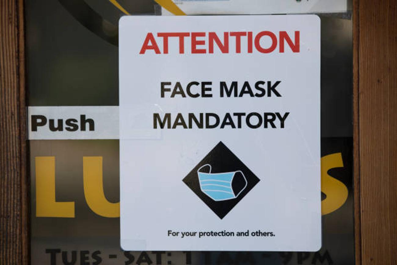 A sign on a restaurant that reads “Attention Face Mask Mandatory”