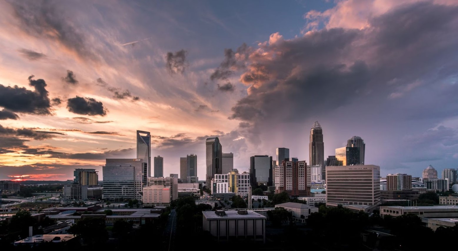 A view of the city of Charlotte in North Carolina. The picture is taken in the evening and there are tall skyscrapers in the center.