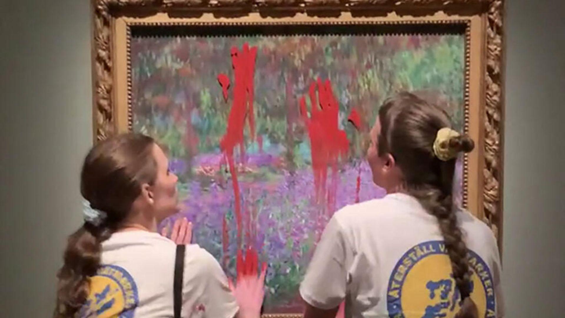 Two climate activists smearing red paint on a Monet painting.