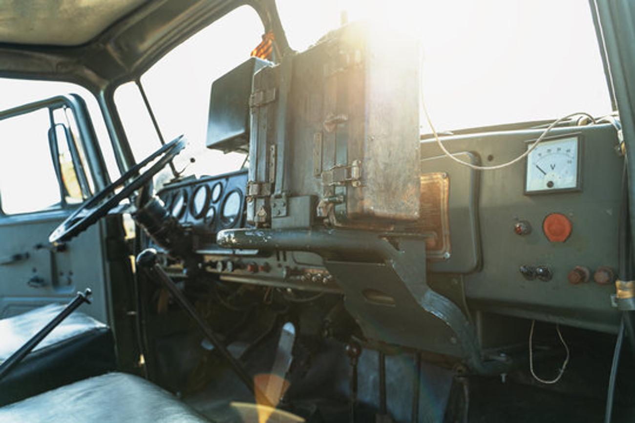 The insides of an army vehicle as the sun shines through the window