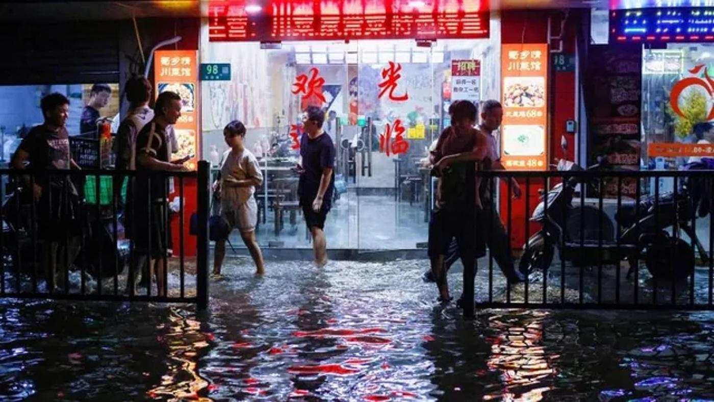 People walk around the flooded streets of China