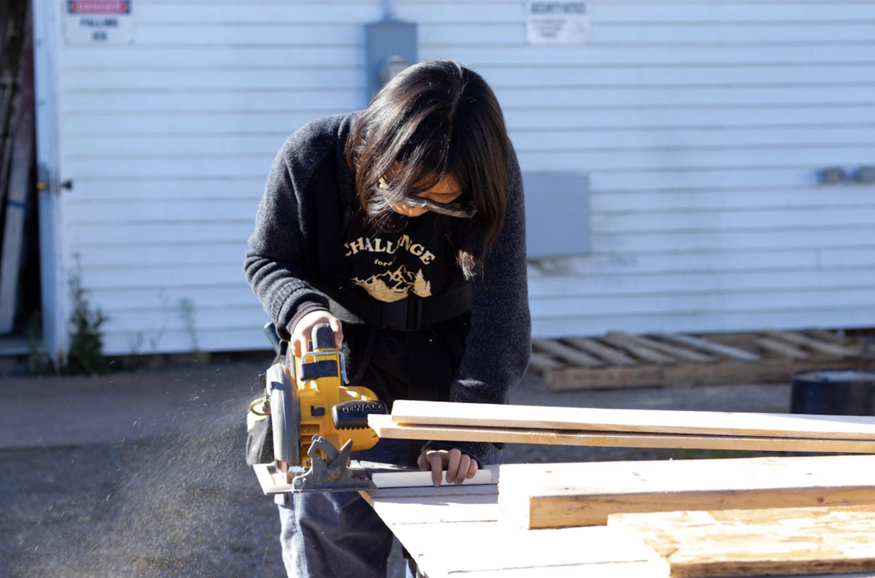 An image of a woman cutting several wooden floorboards