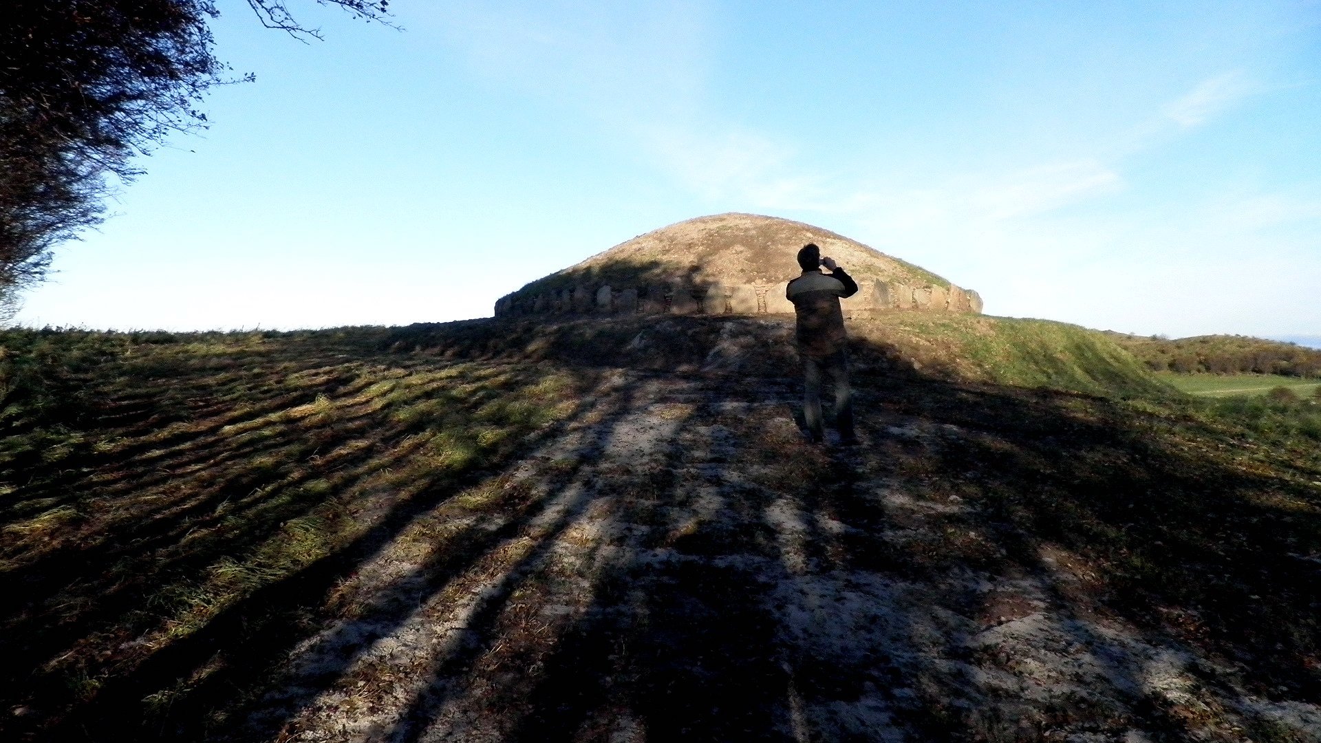 A man taking a photo of the Hulbjerg Jættestue