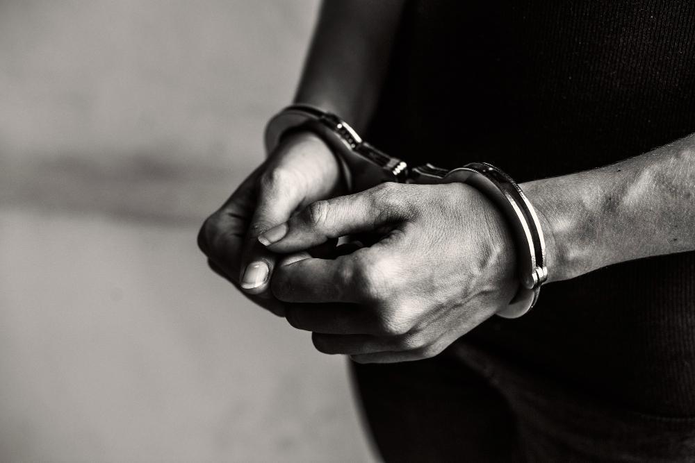 A photograph of a man in cuffs