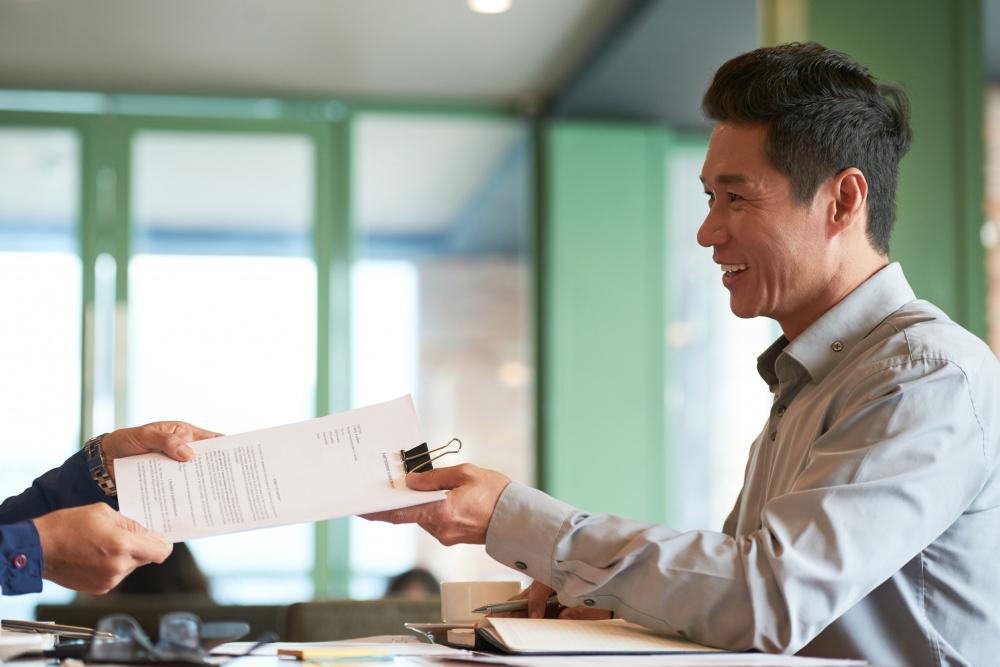 A photograph of a man receiving paperwork