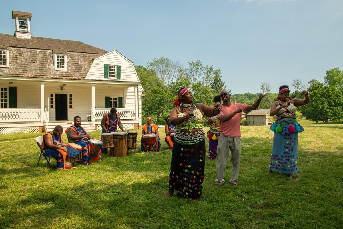 A photograph of a group of African Americans participating in traditional music during the 2019 holiday