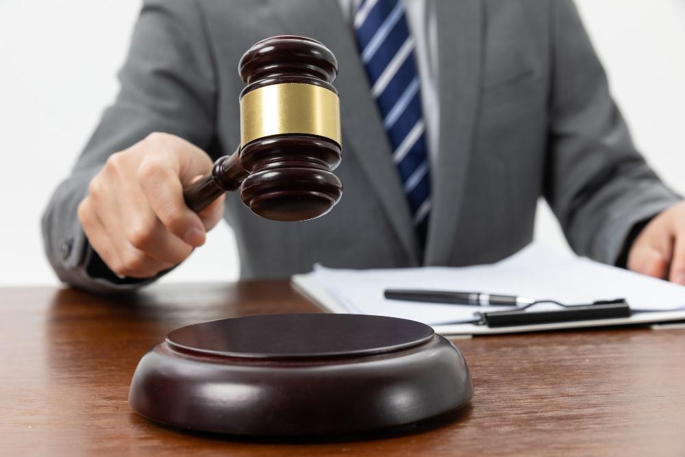 A photograph of a judge in a suit as he bangs his hammer
