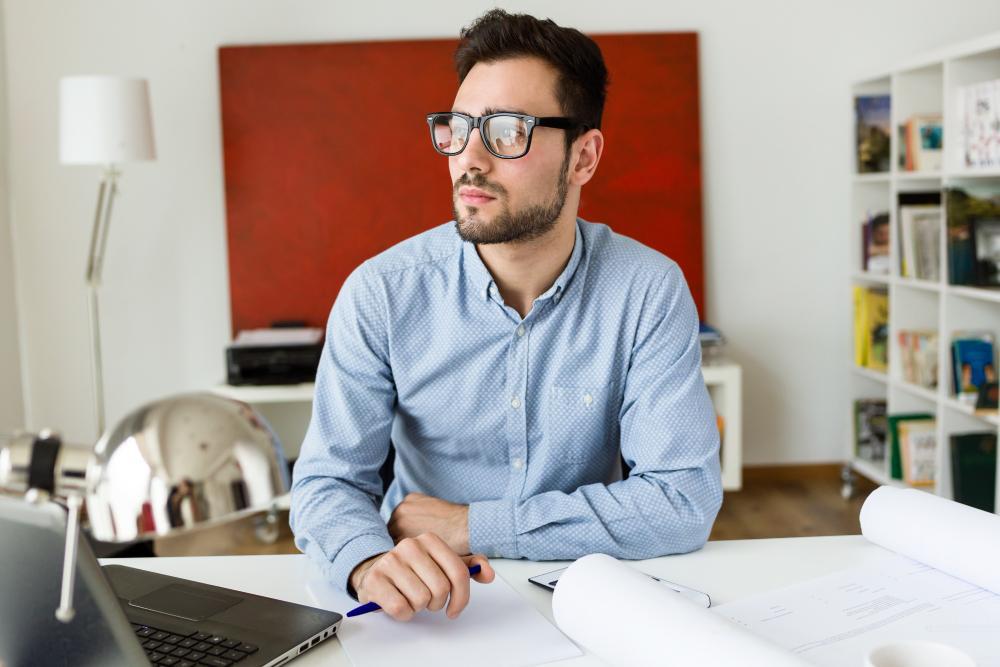 A researcher is pictured seated at his desk