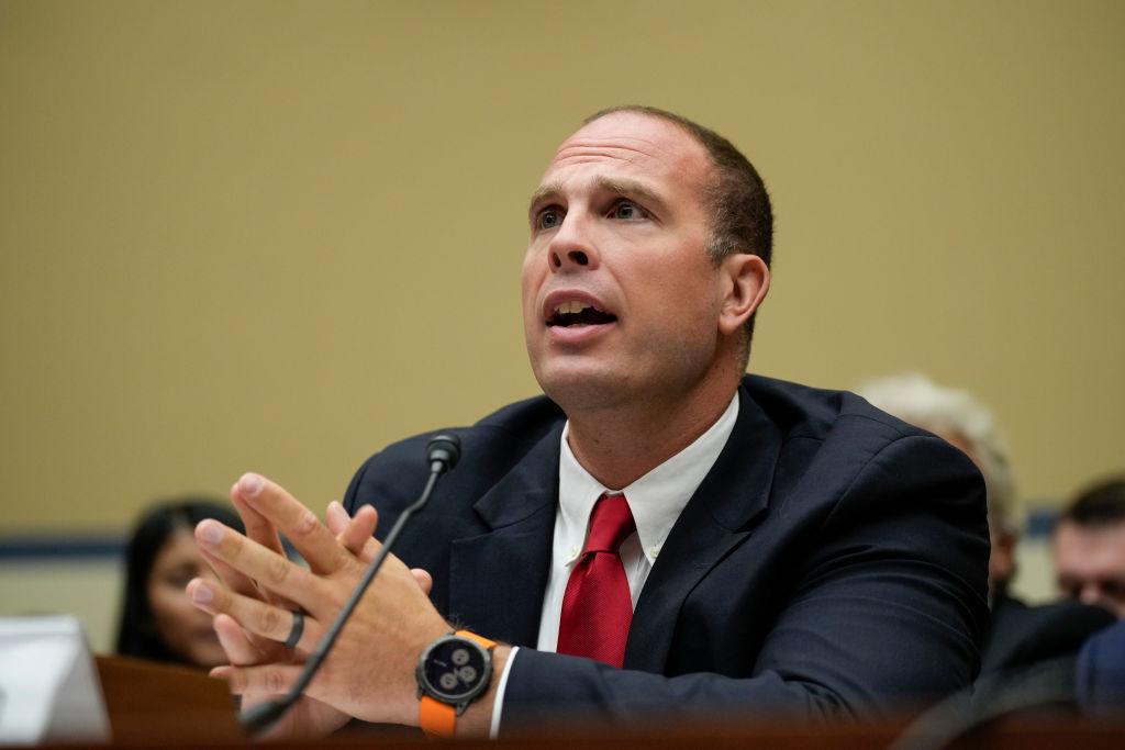 A photograph of David Grusch during a hearing