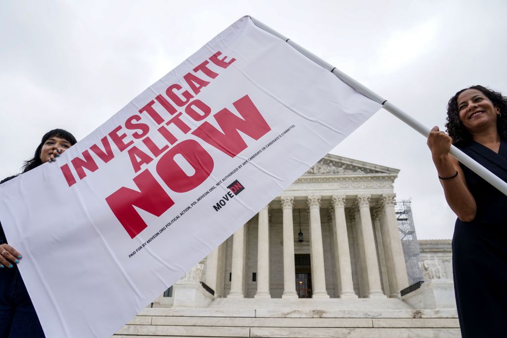 Women hold flag calling for investigation in Justice Alito