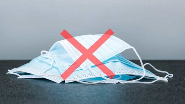 pile of medical face masks with a red X over them