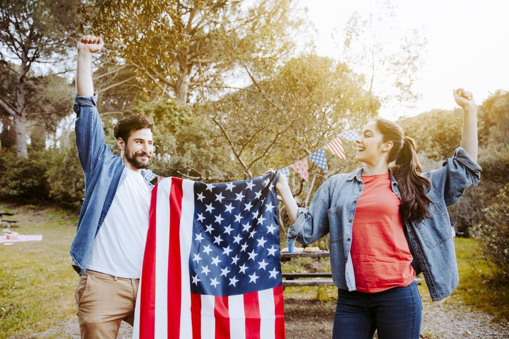 A photograph of two Amercians holding up the national flag