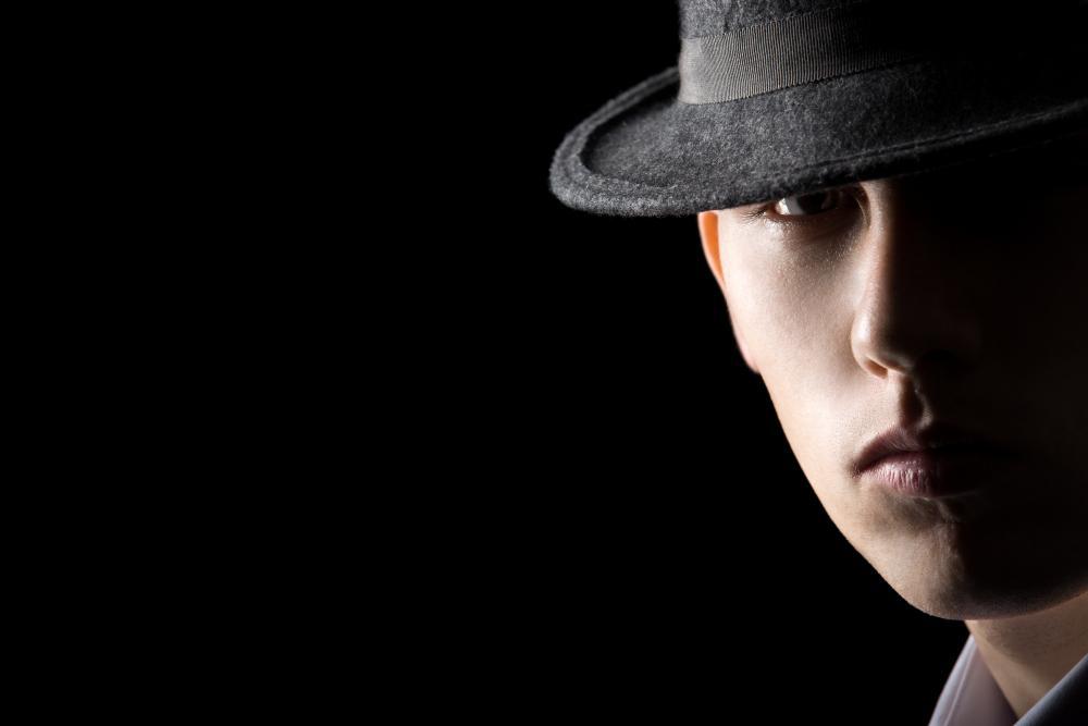 A mysterious man pictured wearing a shirt and a hat