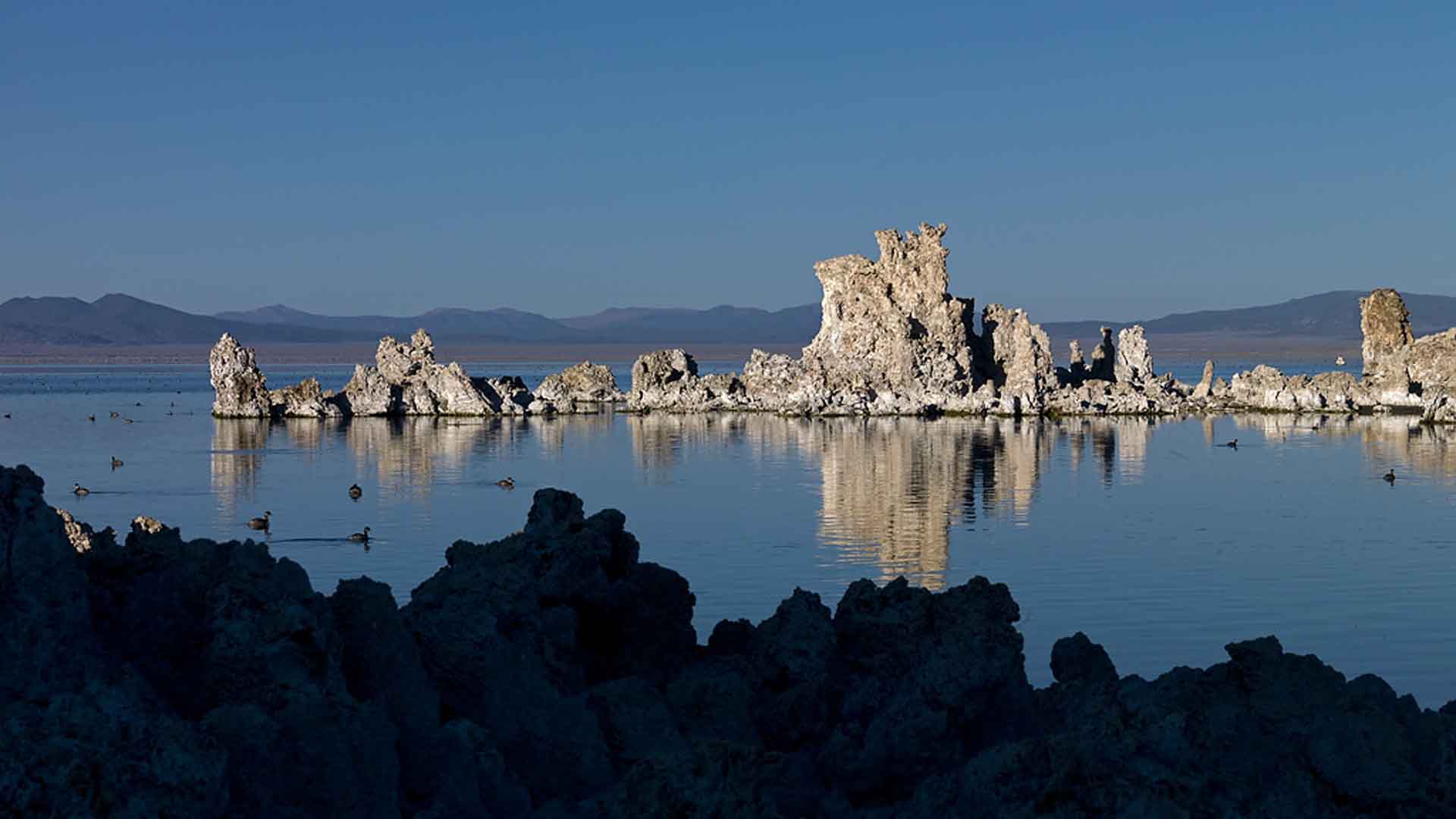 Lake Mono with rocks in background during day