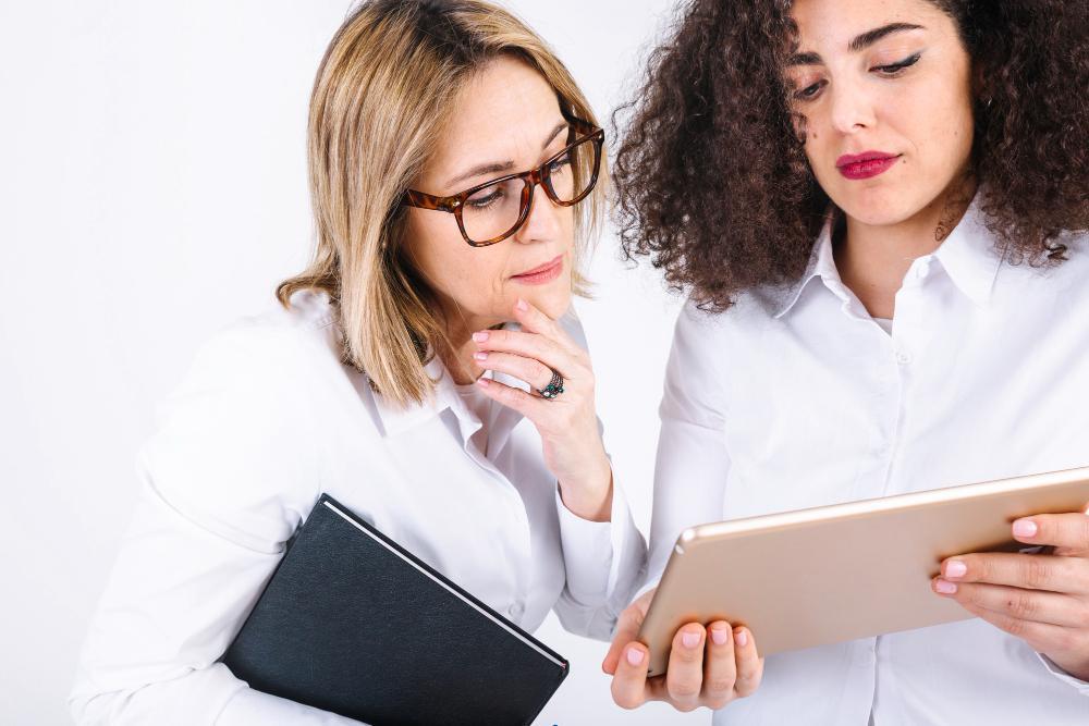 Two women are pictured looking at an iPad