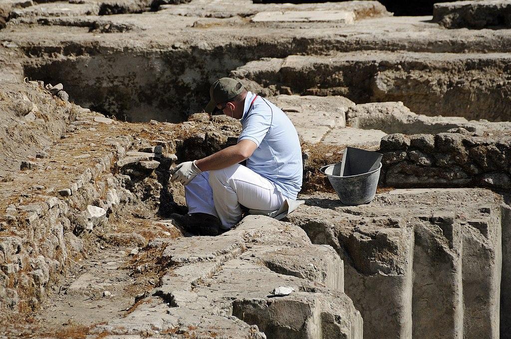A photograph of an archaeologist working at a site