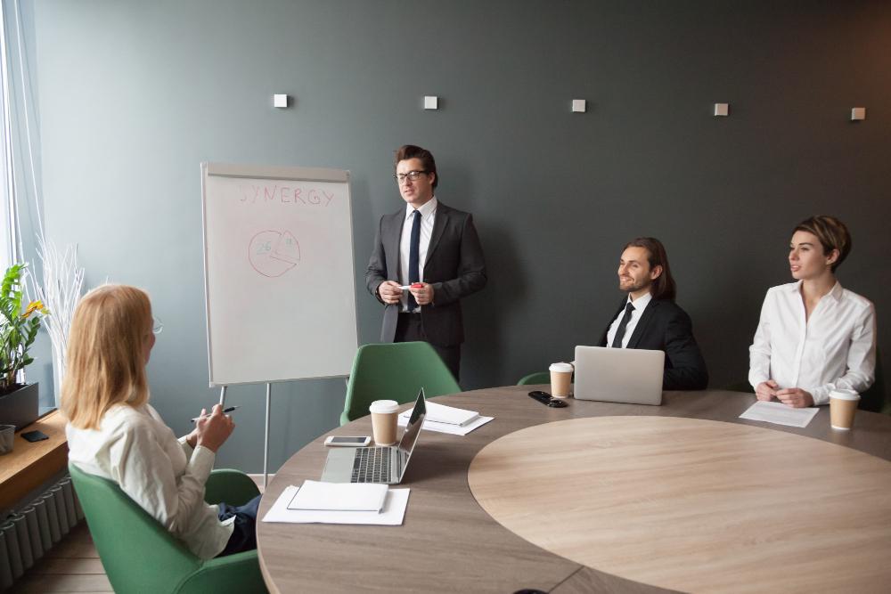A photograph of several people meeting for a discussion in a small office