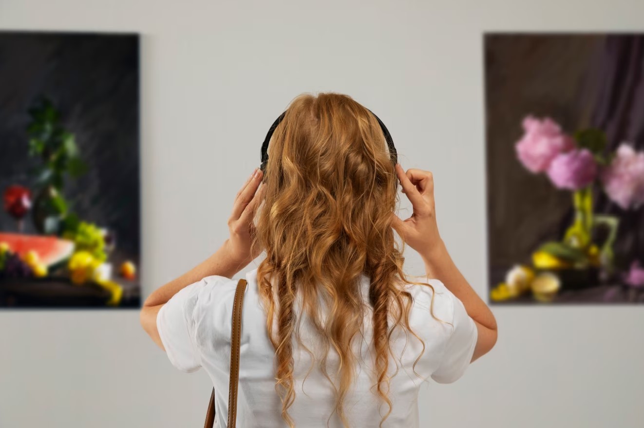 Girl listening to headset in a museum while looking at art