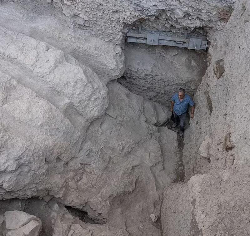 A photograph of an archaeologist standing inside the moat