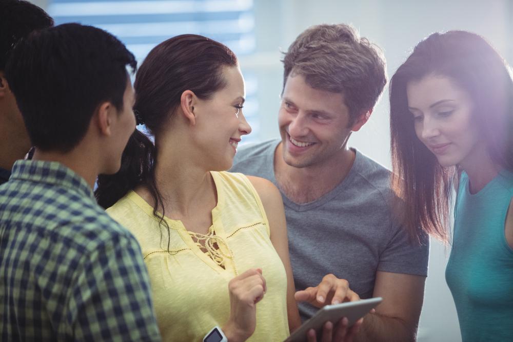 A photograph depicting several friends looking at an image on a phone