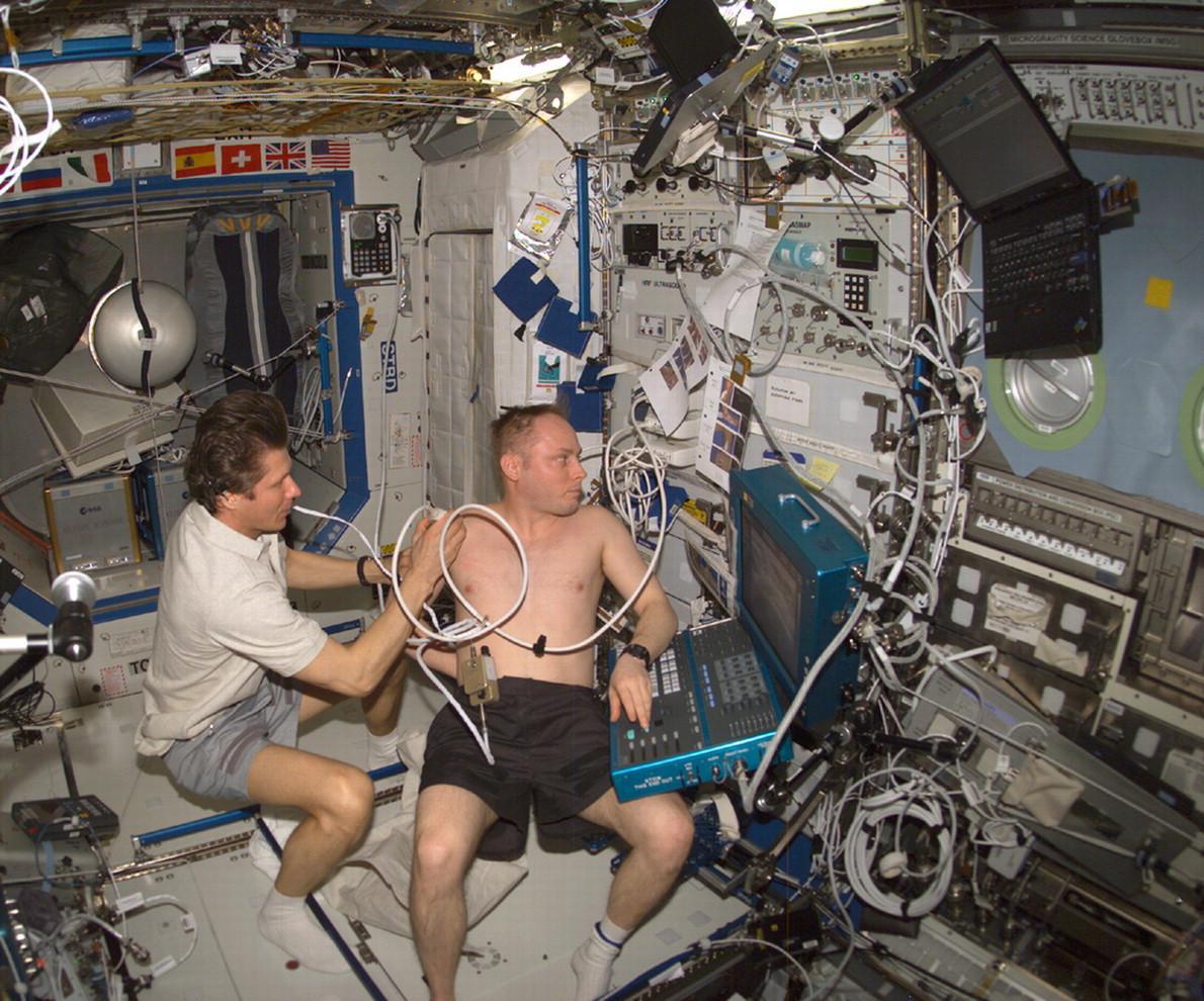 A photograph showing two astronauts running a test aboard the International space station