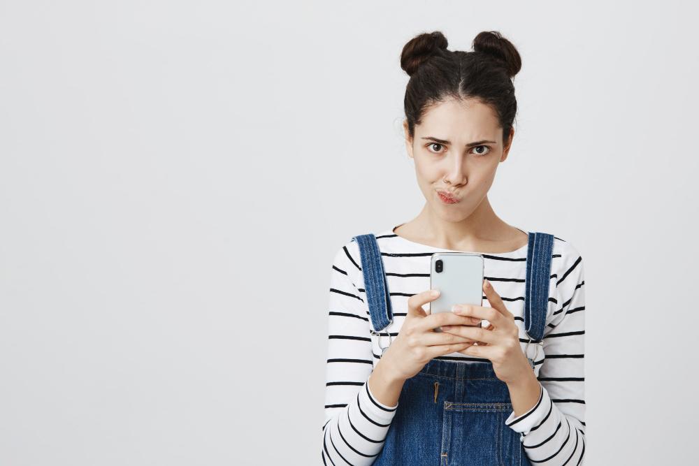A woman is pictured with an unusual face as she uses her smartphone