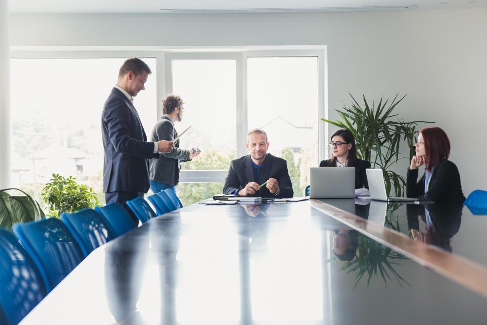 A photograph of several people gathered around a table during a meeting