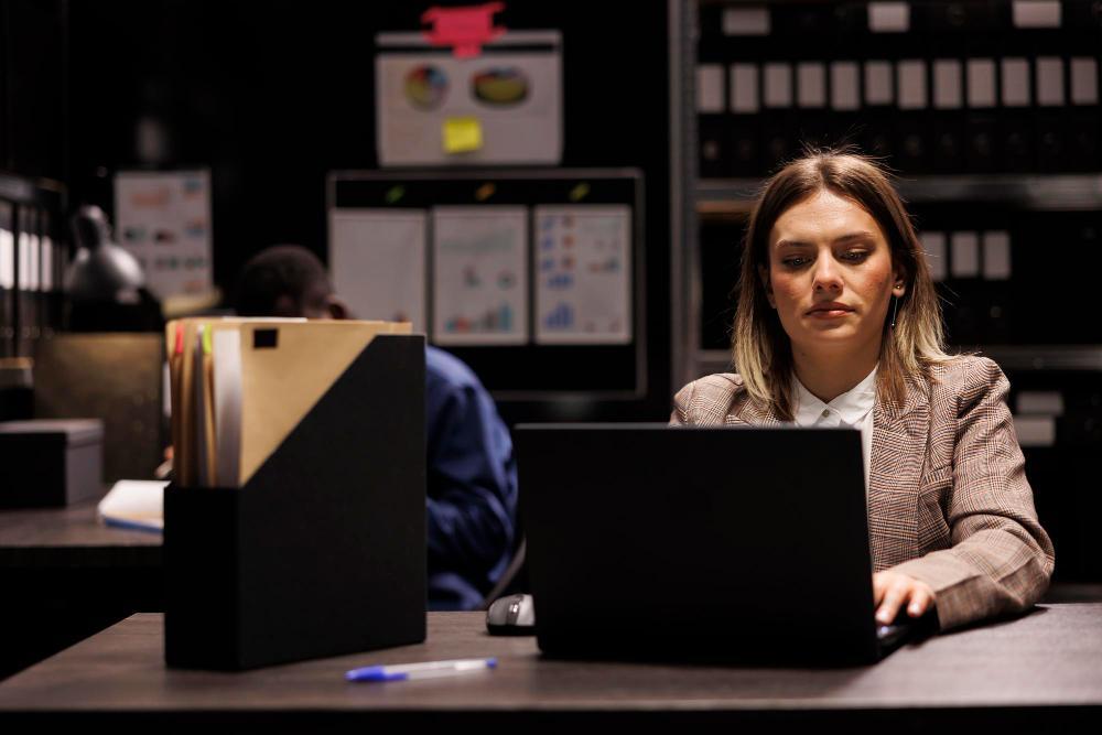 A female investigator is pictured working at her desk