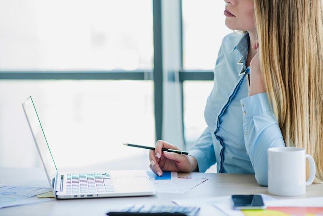A photograph of a woman at her desk