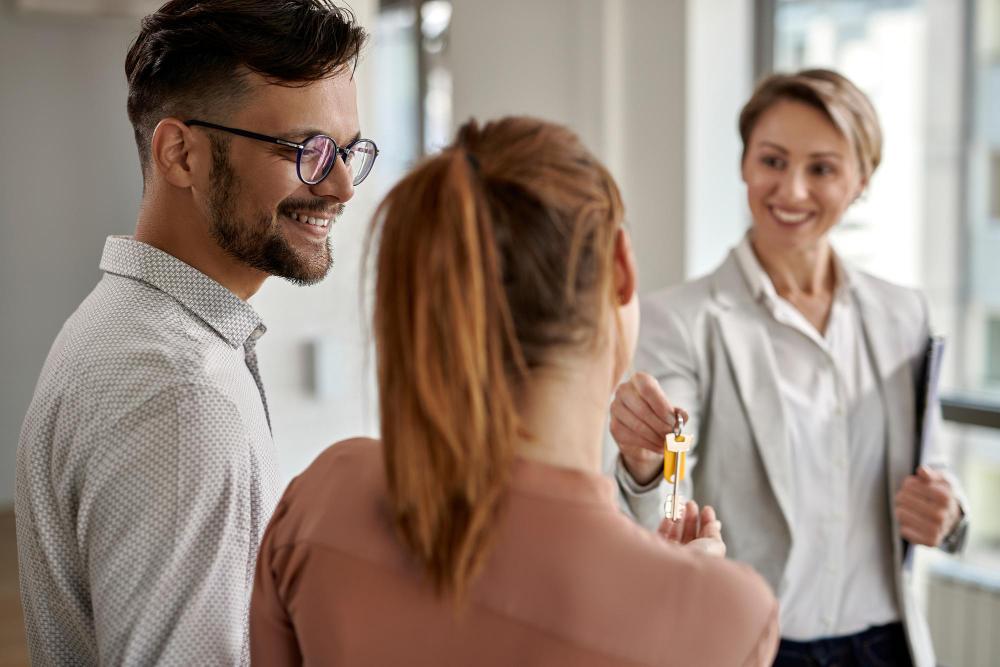 A photograph of a couple receiving the keys to a new home