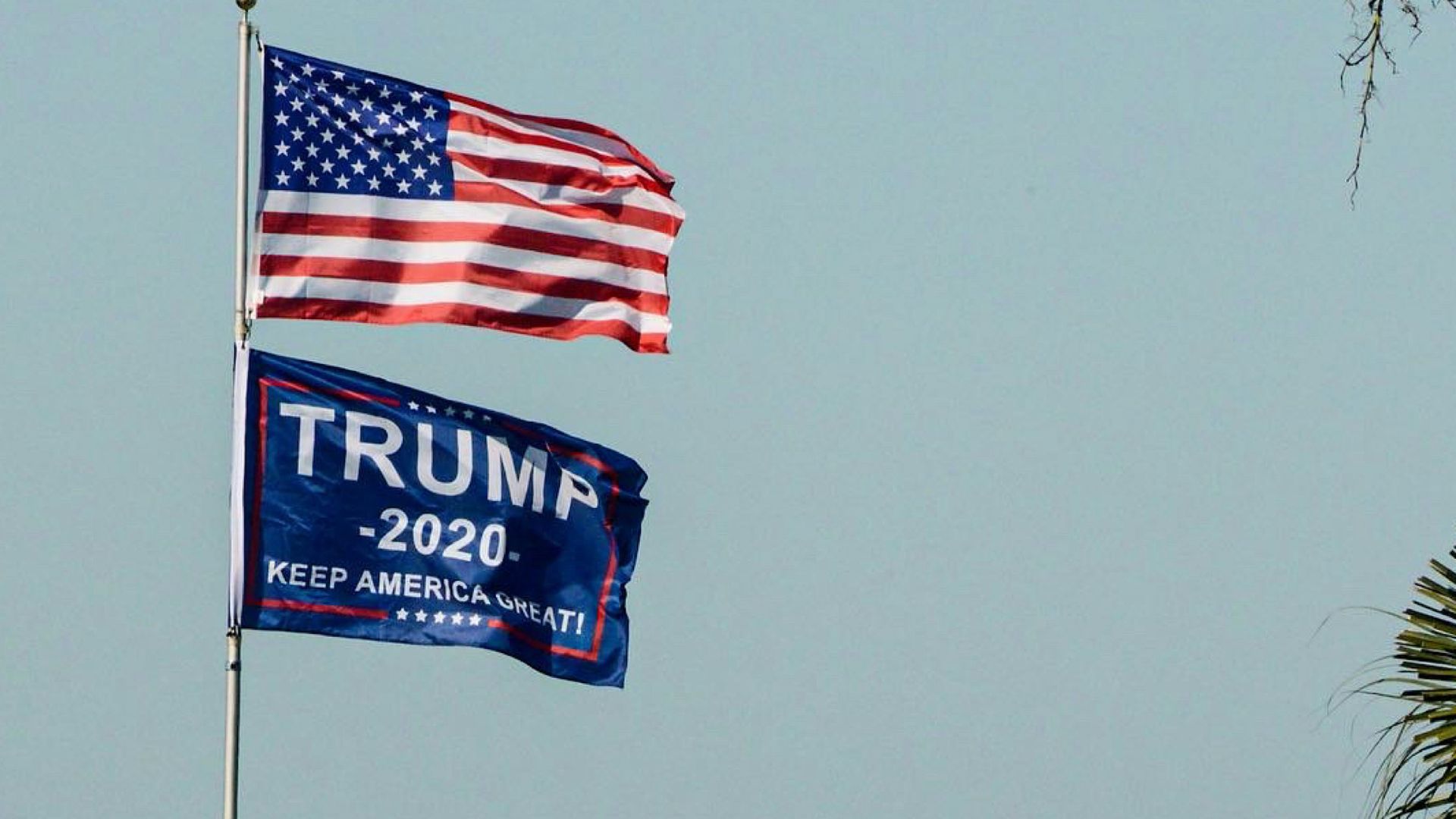 An American flag next to a Trump 2020 flag