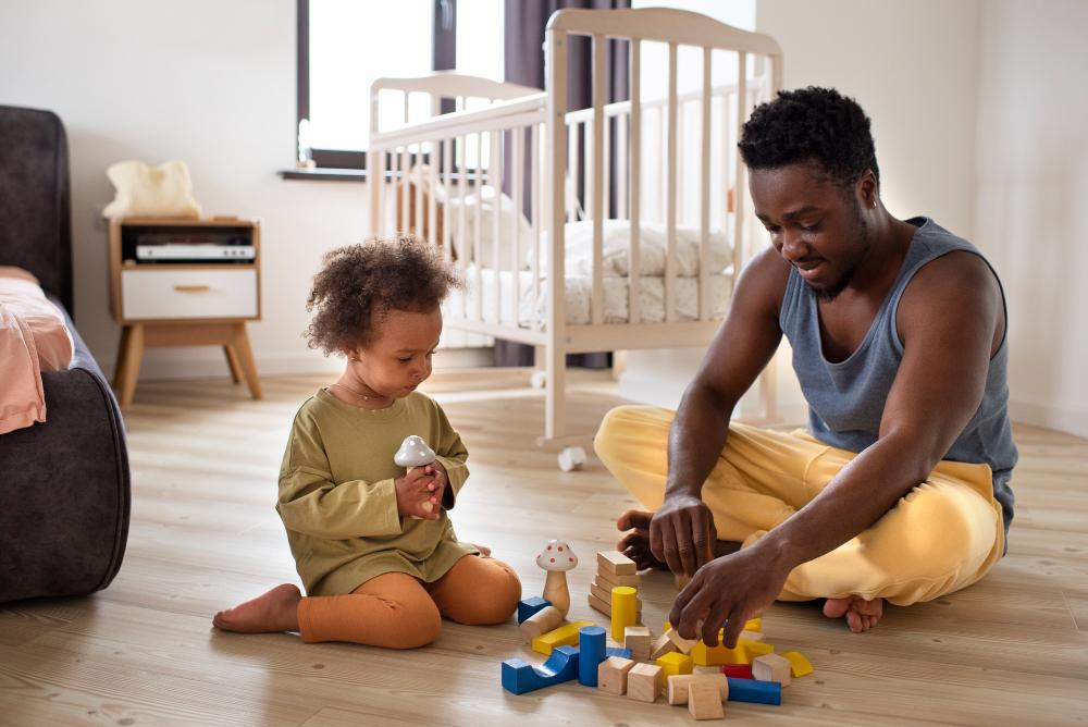A photograph of a black father playing with his child