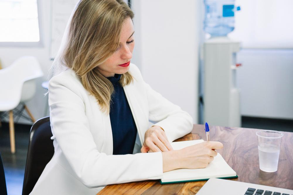 A photograph of a woman writing a report