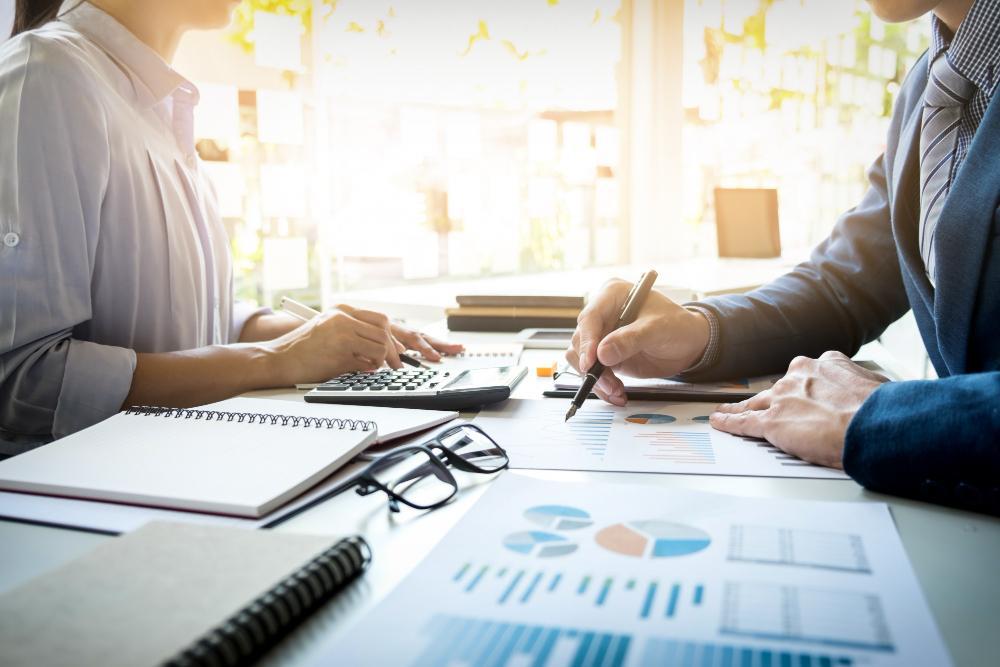 A photograph of several accountants seated at a table working on finances