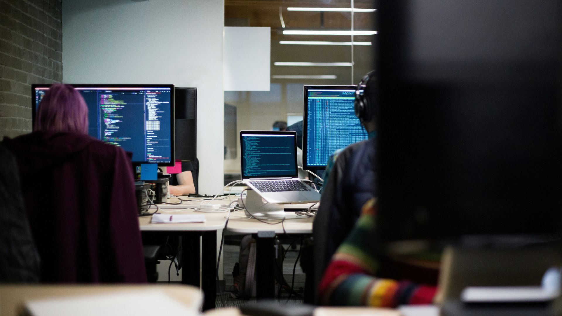 An office setting where people are working on hacking-like programs