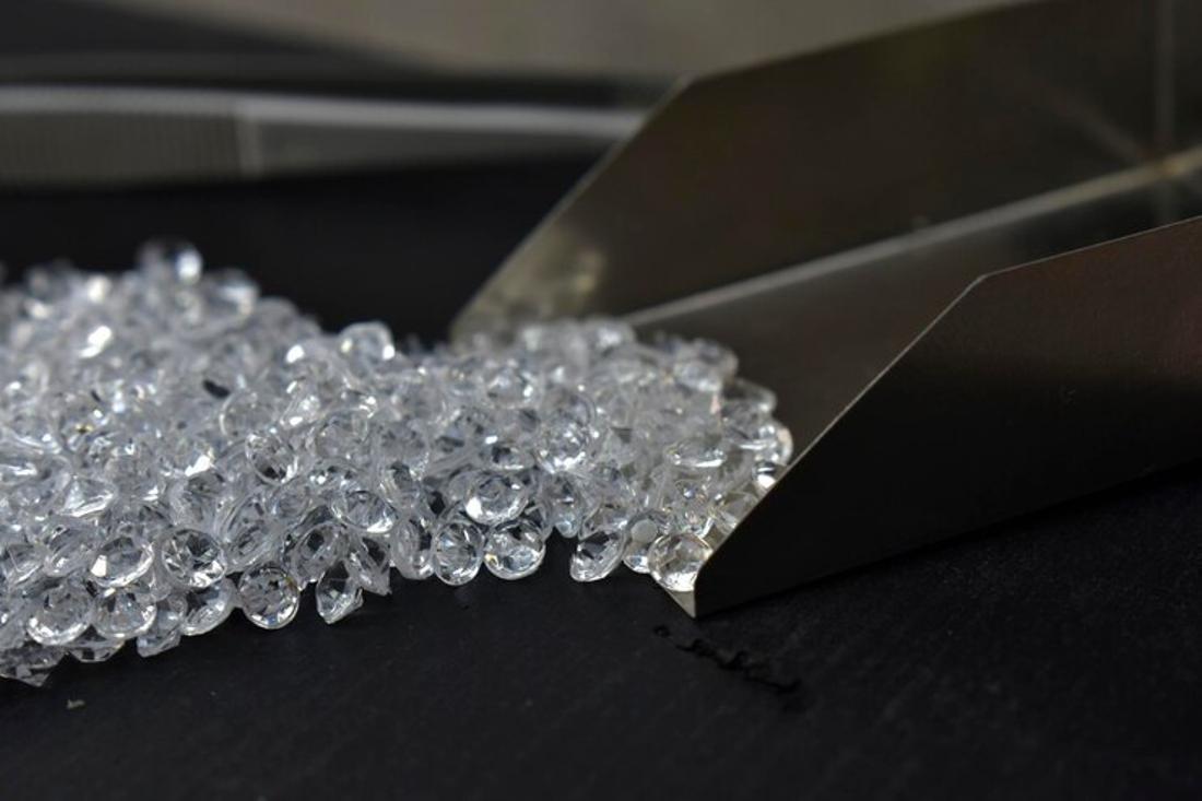 A photograph of numerous small diamonds on a table