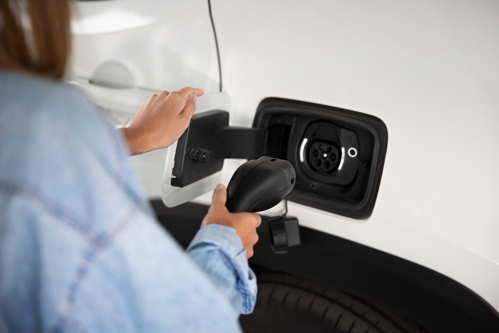 A photograph of a woman inserting a charging cable