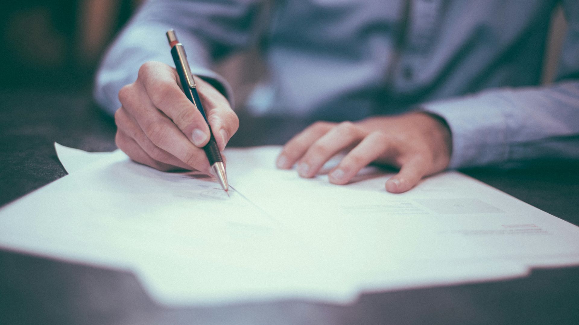 A man using a nice pen to fill out paper work