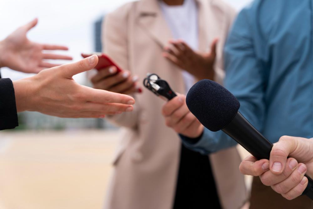 Several reporters are pictured standing around a woman