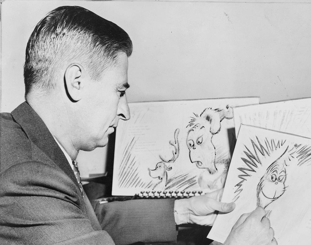 A photograph of Dr. Seuss as he draws an illustration