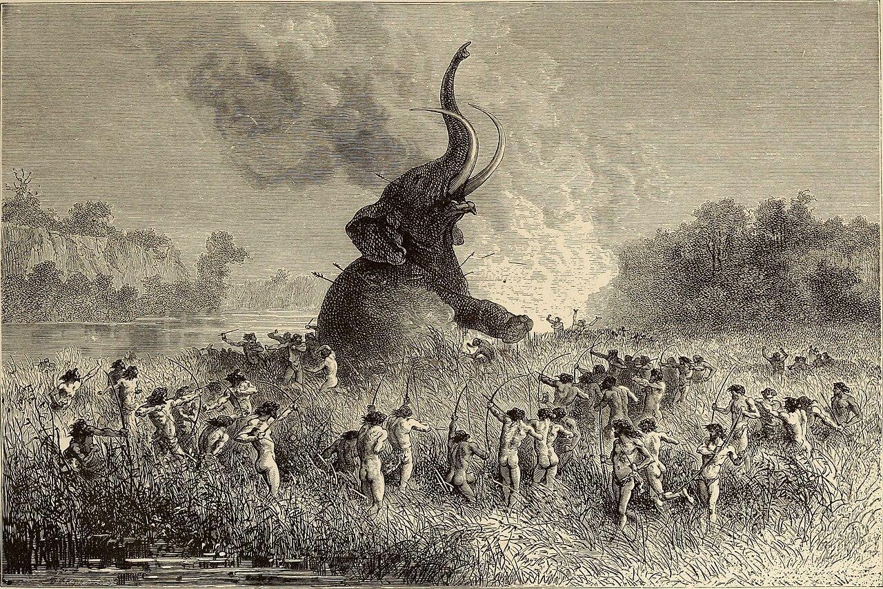 A photograph of humans hunting a large mammoth