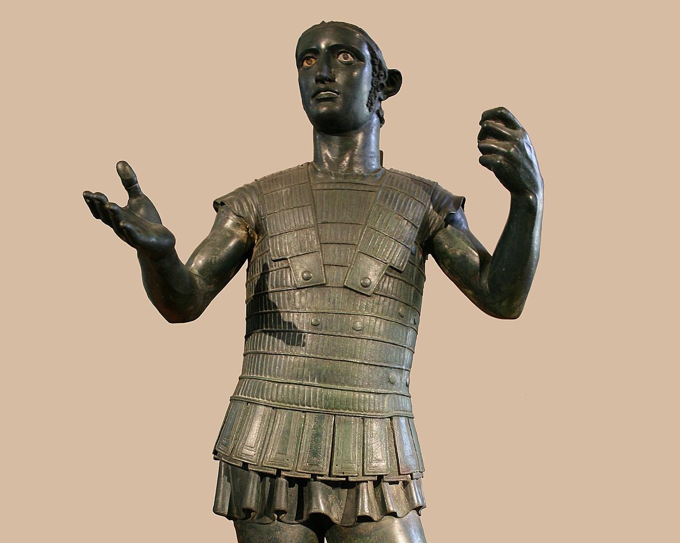 A photograph of an Etruscan figure on display in a museum