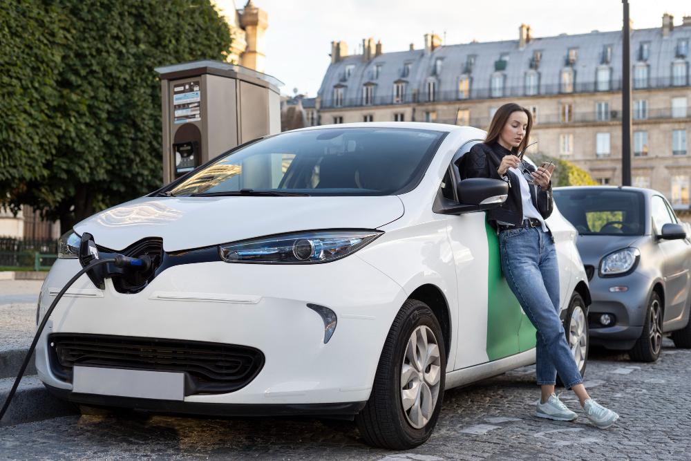 A photograph of a woman charging her electric vehicle