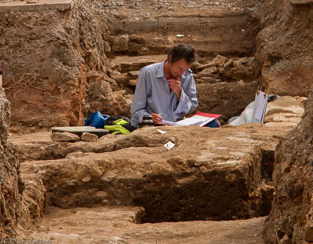 A photograph of an archaeologist working at a site