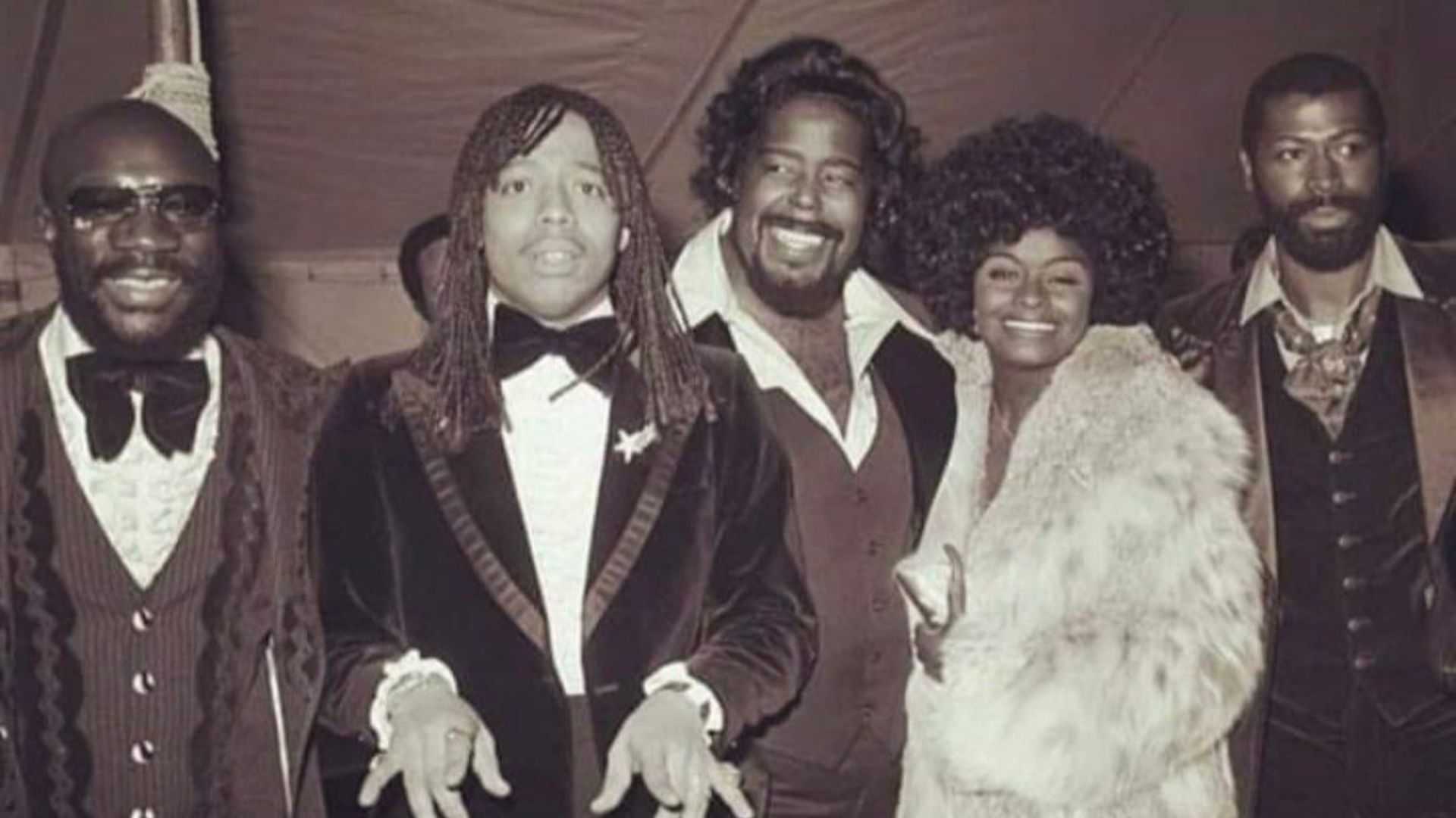 A group of people wearing formal attire pose for a photo