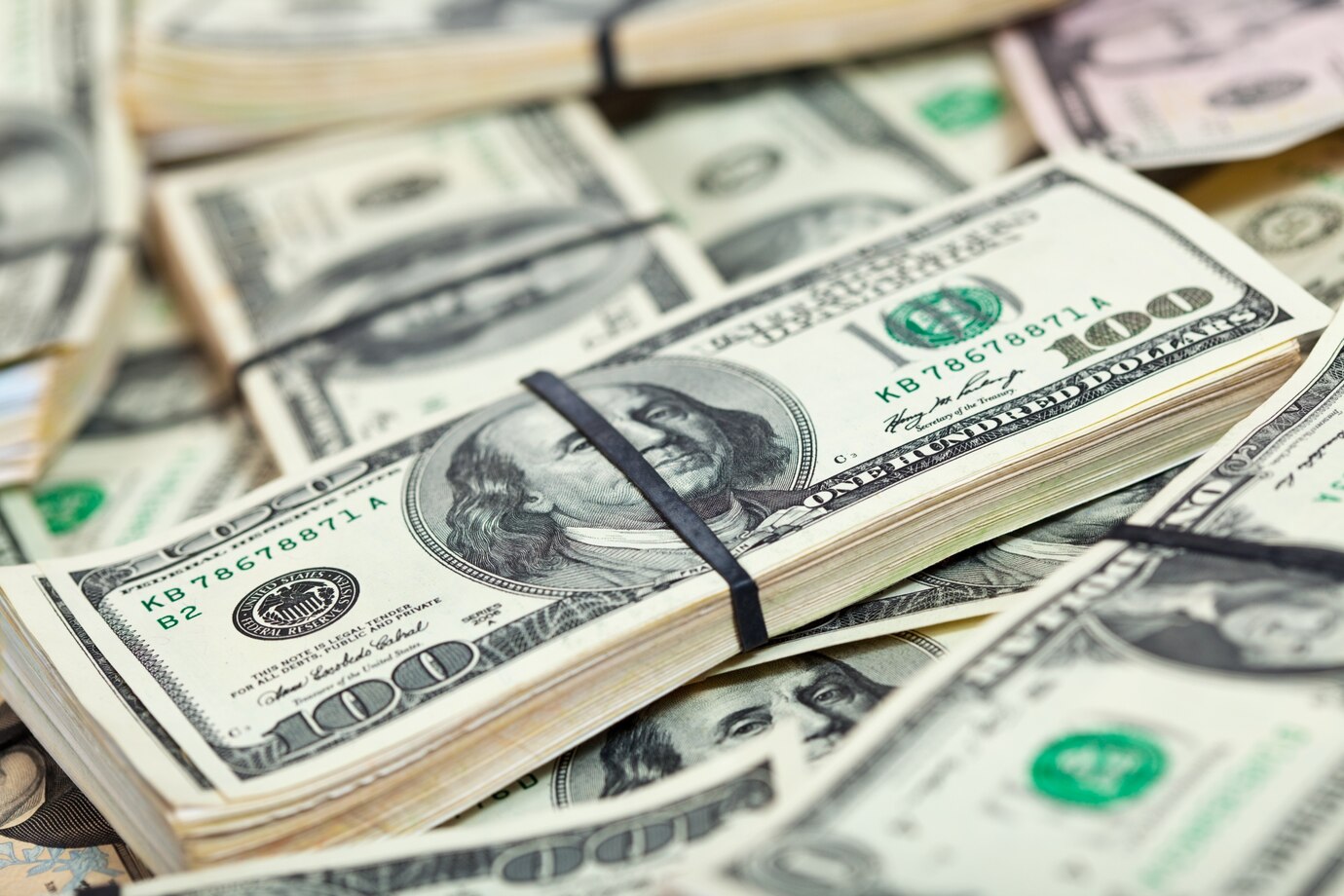 Many USD bills, some with an elastic band over them