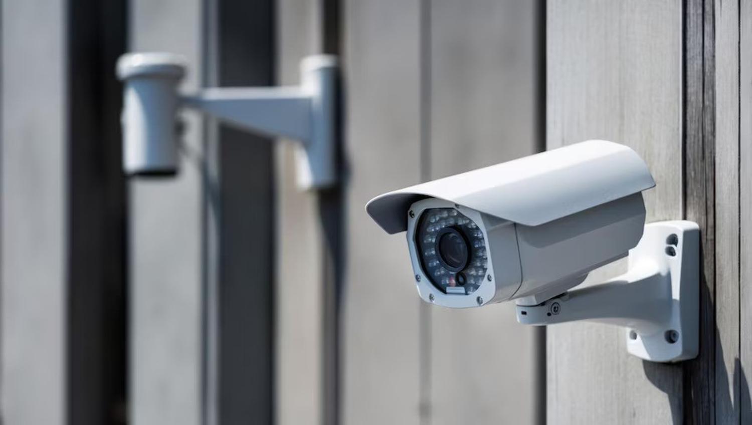 Two security cameras posted outside a building