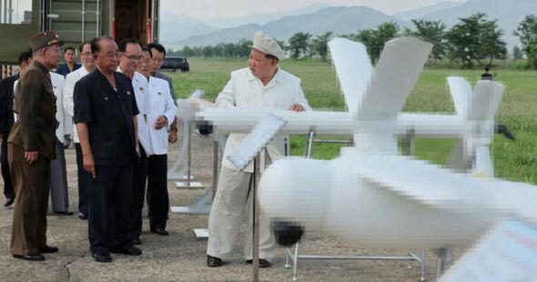 Kim Jong Un observing military weapons that are poorly pixelated